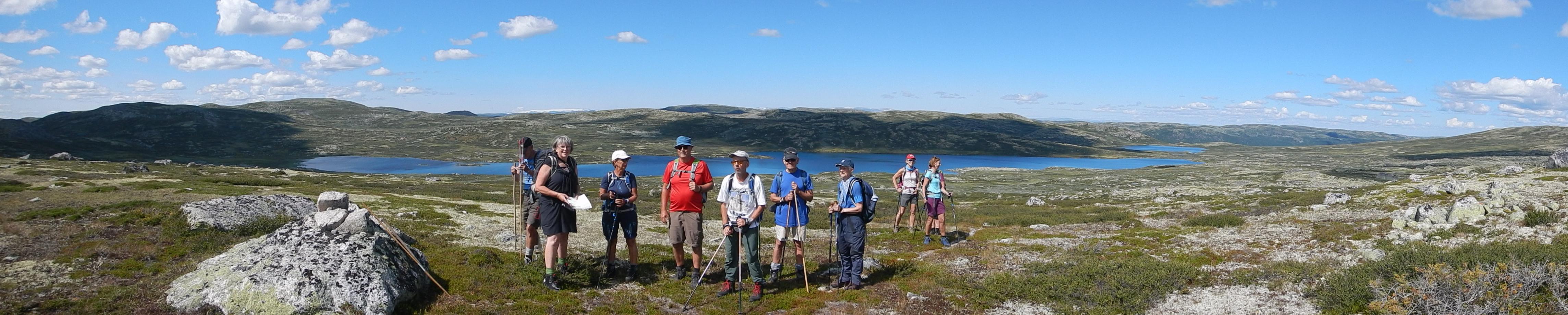 En glad gjeng oppe på vidda med et flott vann i bakgrunnen.