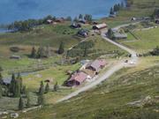 Bildet viser Vangsjøen fjellstue sett fra en høyde over fjellstua. En ser ned på fjellstua med veien som går forbi. I bakgrunnen ses Vangsjøen.